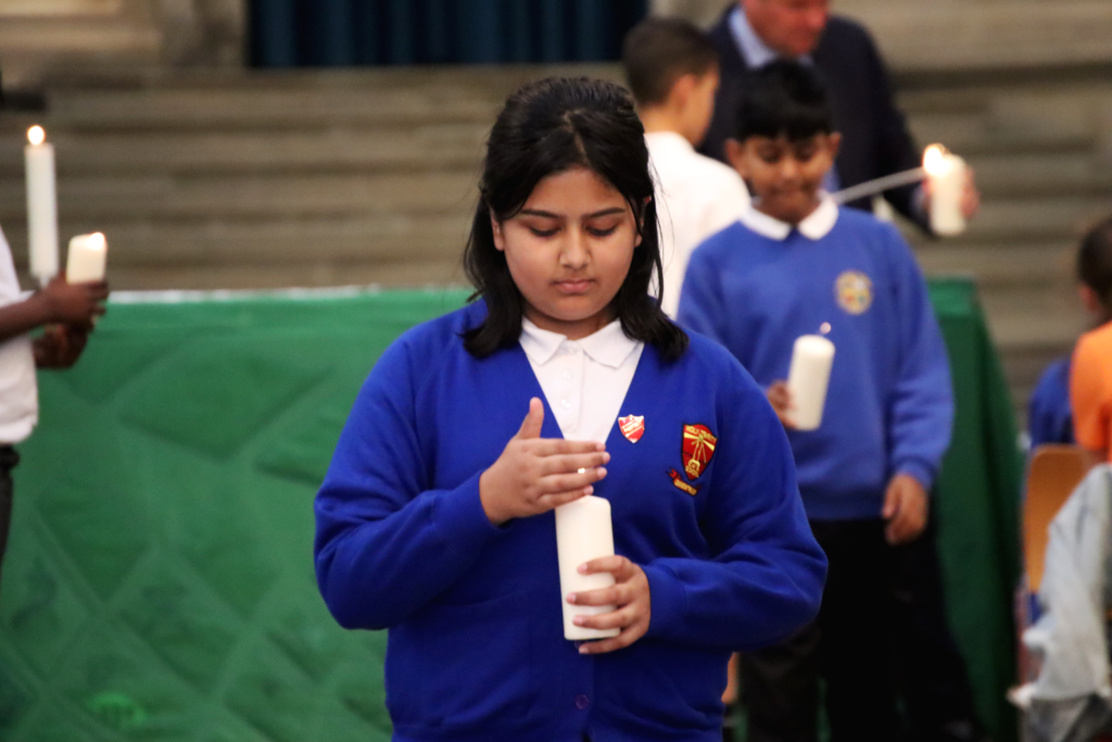 year 6 leavers celebration at rochester cathedral with aletheia academies trust with holy trinity girl holding the leading light